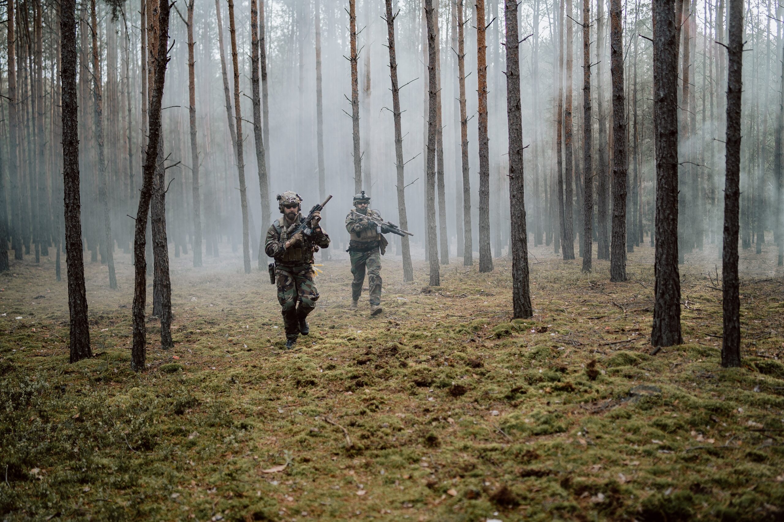 Squad of Four Fully Equipped Soldiers in Camouflage on a Reconnaissance Military Mission, Rifles Ready to Shoot. They’re Moving in Formation Through Dense Cold Forest.